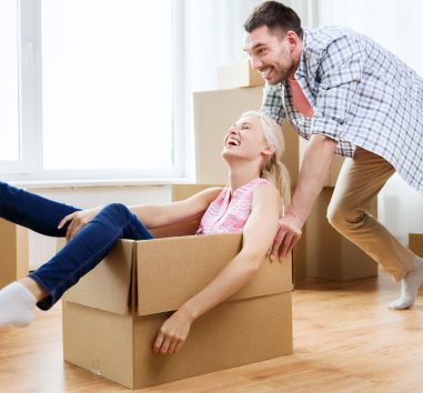 a man pushing a woman into a cardboard box.