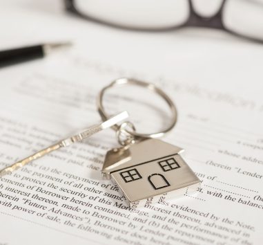 a house keychain sitting on top of a piece of paper.