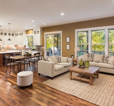 a living room filled with furniture next to a kitchen.