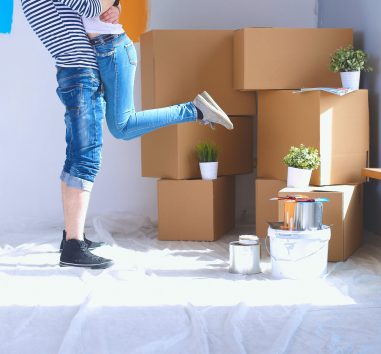 a woman standing in front of a pile of boxes.