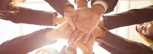 a group of business people stacking their hands together.